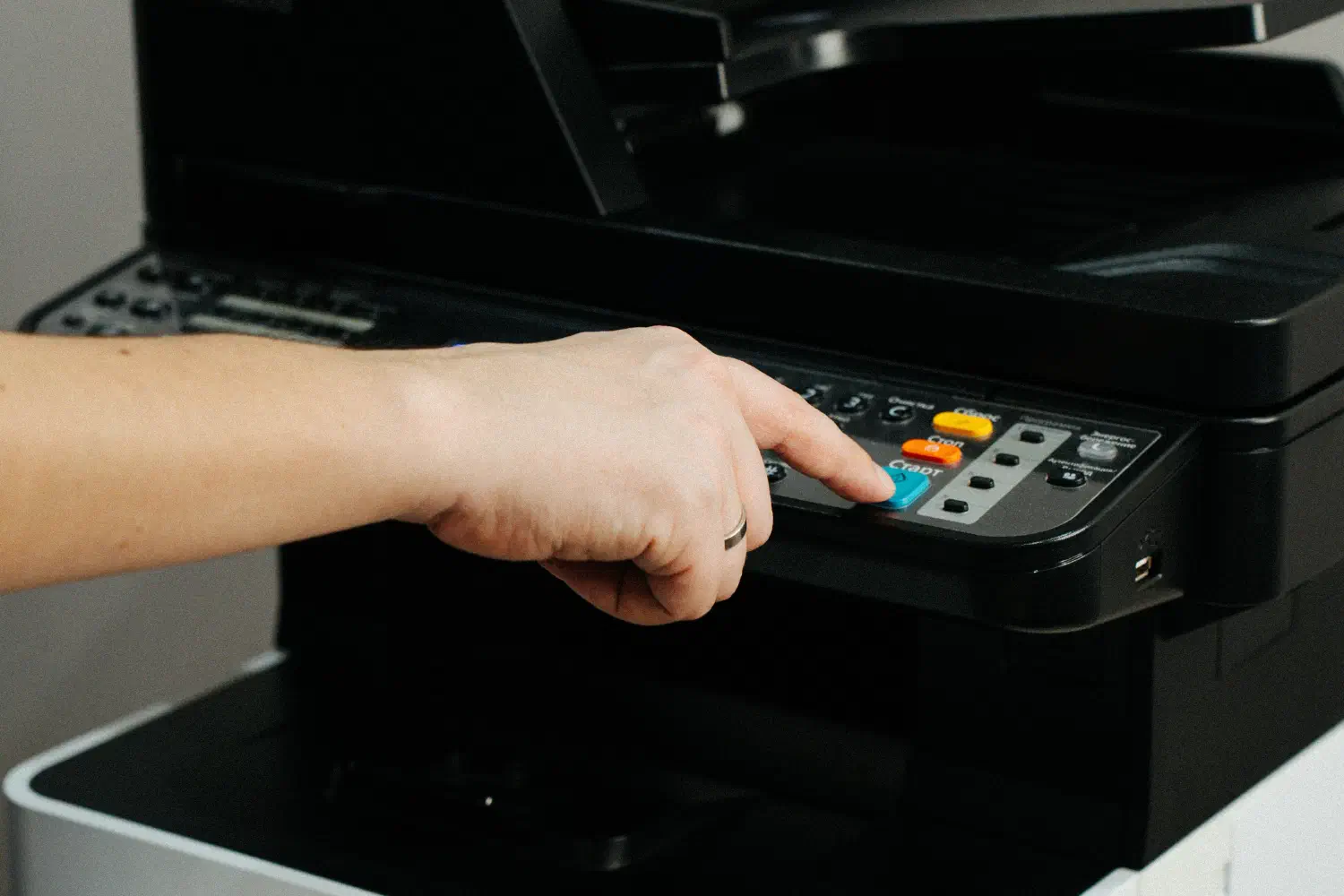 Person drückt Taste auf Drucker